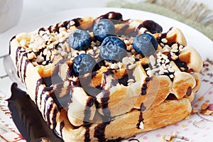 Belgian waffles with peanut chocolate sauce and blueberry, bilberry, whortleberry, huckleberry, hurtleberry, blaeberry
