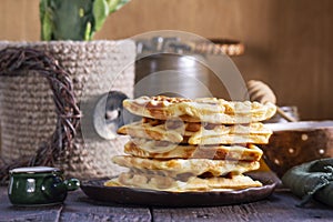 Belgian waffles served with honey, cream and sai on a wooden background. Rustic style.