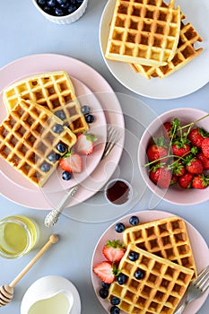 Belgian waffles with strawberries and honey on gray background. Healthy breakfast concept