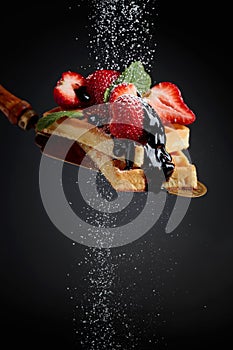 Belgian waffles with strawberries, mint and chocolate sauce