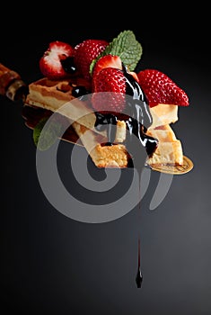 Belgian waffles with strawberries, mint and chocolate sauce