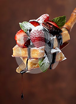 Belgian waffles with strawberries, mint and chocolate sauce