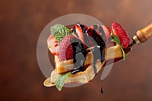 Belgian waffles with strawberries, mint and chocolate sauce