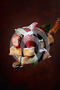 Belgian waffles with strawberries, mint and chocolate sauce