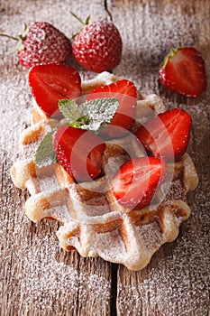 Belgian waffles with strawberries and powdered sugar close-up. v