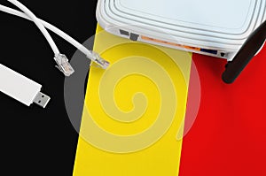 Belgium flag depicted on table with internet rj45 cable, wireless usb wifi adapter and router. Internet connection concept