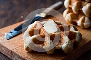 Belgium Waffle with Butter on wooden surface.