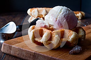 Belgium Waffle with ice cream on wooden surface.