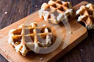 Belgium Waffle with Maple Syrup on wooden surface.