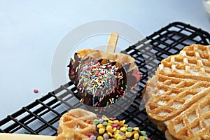 Belgium waffles with chocolate sauce. popsicles with chocolate and wafer on blue background