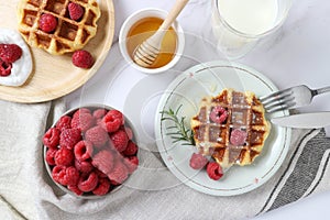 Belgium waffles with fresh raspberries, honey and milk : Breakfast concept top view close up Traditional waffle