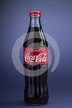 Belgorod , Russia - MAY, 28, 2020: Classic Coca-Cola bottle on Blue Background. Carbonated soft drink produced by Coca-Cola