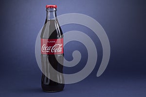 Belgorod , Russia - MAY, 28, 2020: Classic Coca-Cola bottle on Blue Background. Carbonated soft drink produced by Coca-Cola