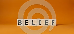 Belief symbol. Concept word Belief on wooden cubes. Beautiful orange background. Business and Belief concept. Copy space