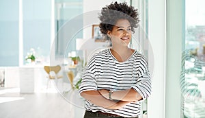 Believe it and achieve it. a young businesswoman looking thoughtfully out the window in an office.