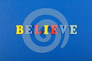 BELIEVE word on blue background composed from colorful abc alphabet block wooden letters, copy space for ad text. Learning english