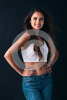 Believe in your beauty. Studio shot of an attractive young woman posing against a dark background.