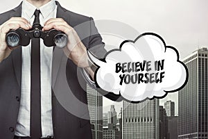 Believe in yourself text on blackboard with businessman