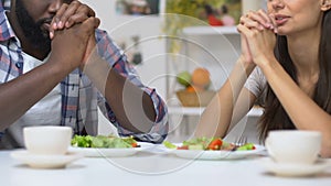 Believing couple praying before dinner, traditions of Christian couple, religion