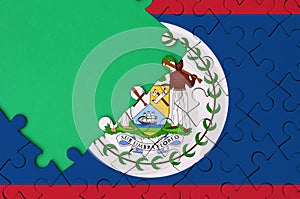 Belize flag is depicted on a completed jigsaw puzzle with free green copy space on the left side