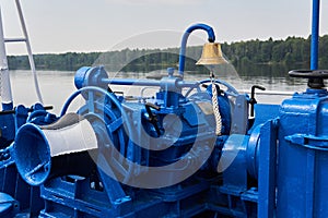 Bell, capstan and other mechanisms, painted blue, on the foredeck of the river ship, close-up