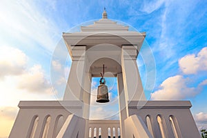 A bell hangs inside the white podium.