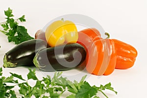 Bell pepper,eggplants and sprigs of parsley on a white background.