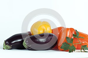 Bell pepper,eggplants and sprigs of parsley on a white background.