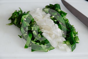 Bell pepper and onion cut with a knife to prepare a meal