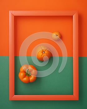 Bell pepper, orange, clementine in  frame on orange and green