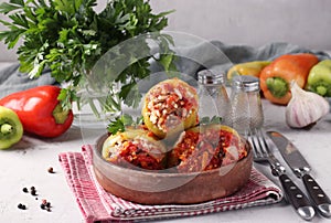 Bell Pepper Stuffed with rice and minced beef in tomato sauce in a plate on light gray background