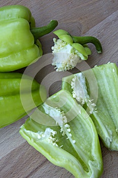 Bell peppers, cut into halves and whole. Fresh vegetables for cooking lie on a wooden background. Vertical photo