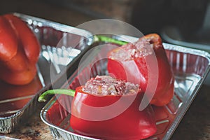 Bell peppers stuffed with minced meat filling in a baking aluminum form