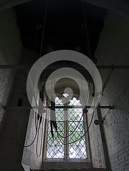 Bell ropes hang neatly from a church belltower. photo