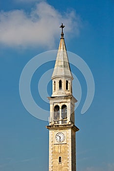 Bell tower of the church in Gallio, Vicenza, Italy against the blue sky with one white cloud photo