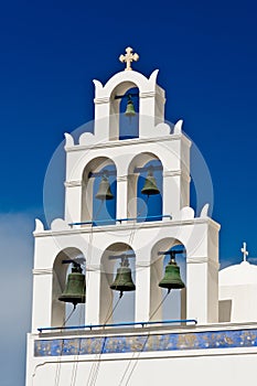 Bell tower of the Church in Oia city at Santorini Island in a beautiful early spring day. Greece.