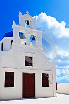 Bell tower of the Church in Oia city at Santorini Island in a beautiful early spring day. Greece. High quality photo