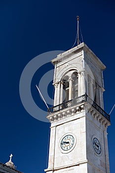 Bell tower with clock in Hydra Island, Greece on sunne day with clear classic blue sky