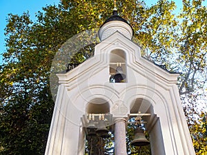 Bell tower of Cross Exaltation Church in Livadia Palace Complex. Close-up of white stone belfry