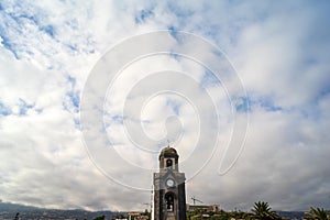 Bell tower of Nuestra Senora de la Pena de Francia on the cloudy sky background.