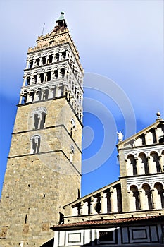 Bell tower and part of the cathedral of San Zeno framed illuminated by the sun and framed by the blue sky veiled by light clouds,