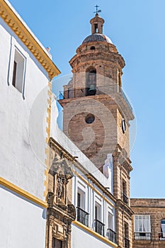 Bell tower and perspective of Santo Domingo convent with pediment and religious statue above the entrance door, CÃ¡diz SPAIN photo