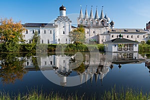 The bell tower of the Tikhvin Assumption Bogorodichny Uspensky   Monastery with a reflection in the pond. Tikhvin,