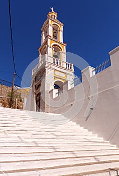 Bell tower of a traditional Greek Orthodox church on a narrow street of Symi island