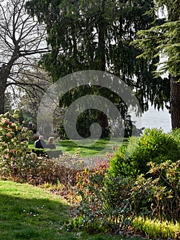 Bellagio, Italy  March 30 2019 Couple sitting in a garden to comtemplate the view of Lake Como