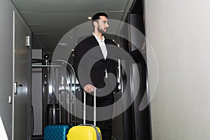 bellboy in suit standing near luggage