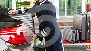 Bellboy taking baggage of guest from thee car to his room