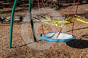 BELLEVUE, WA/USA â€“ MAY 18, 2020: Wilburton Hill Park, COVID 19 response, yellow caution tape closing off a swing in a playground