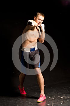 Belligerent young boxer throwing a punch photo