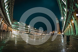 Belltower and church on piazza San Marco in Venice, Italy during a rainy night time, with reflections on the floor. Beautiful